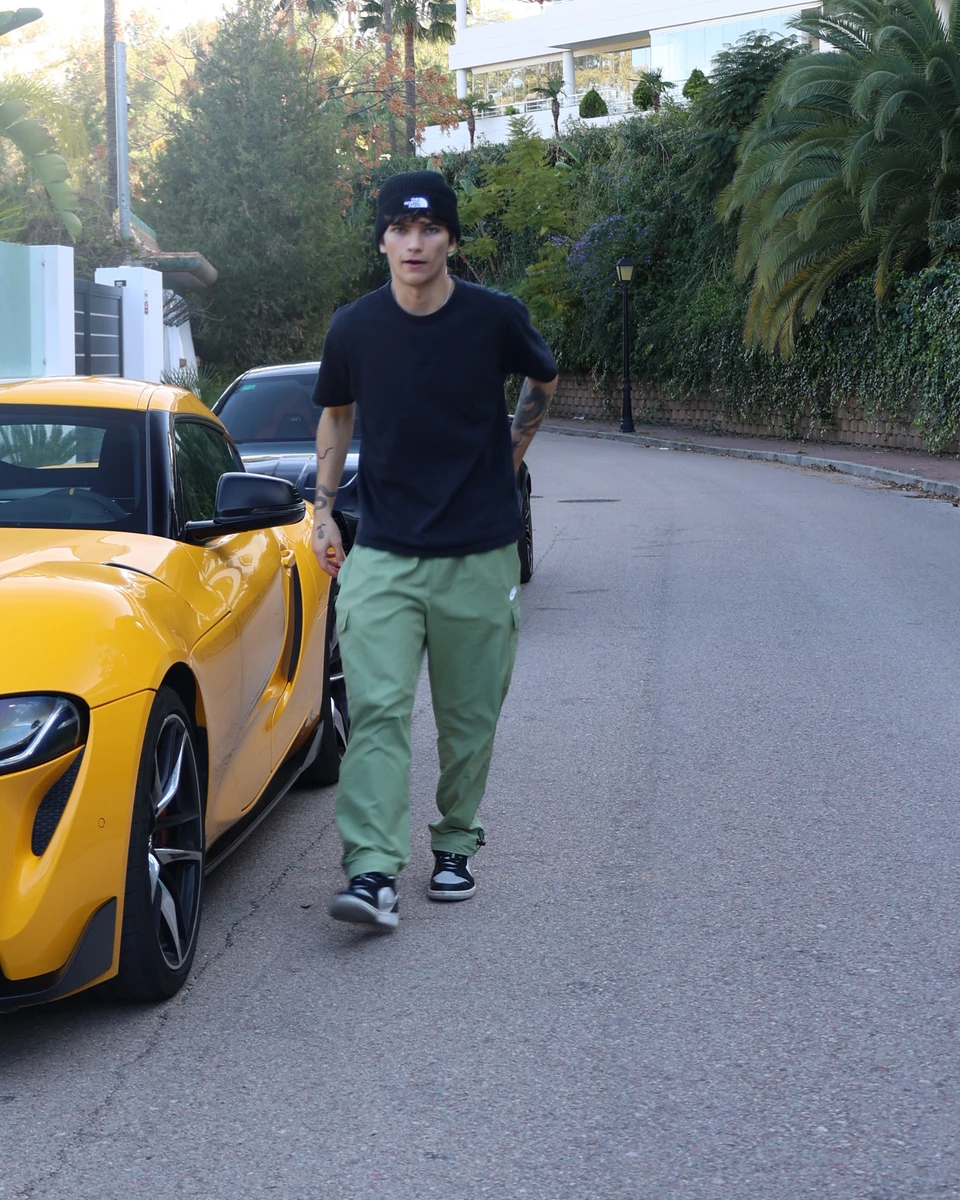 Aaron standing outdoors beside a yellow car